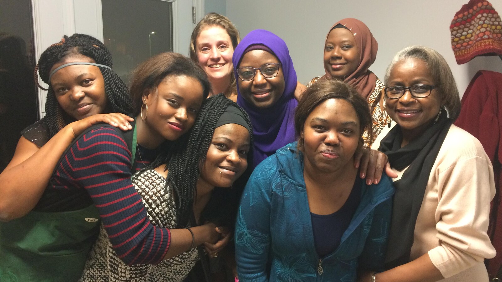Des femmes d'origine africaine s’enlacent et sourient lors d'une soirée organisée au Témiscamingue.