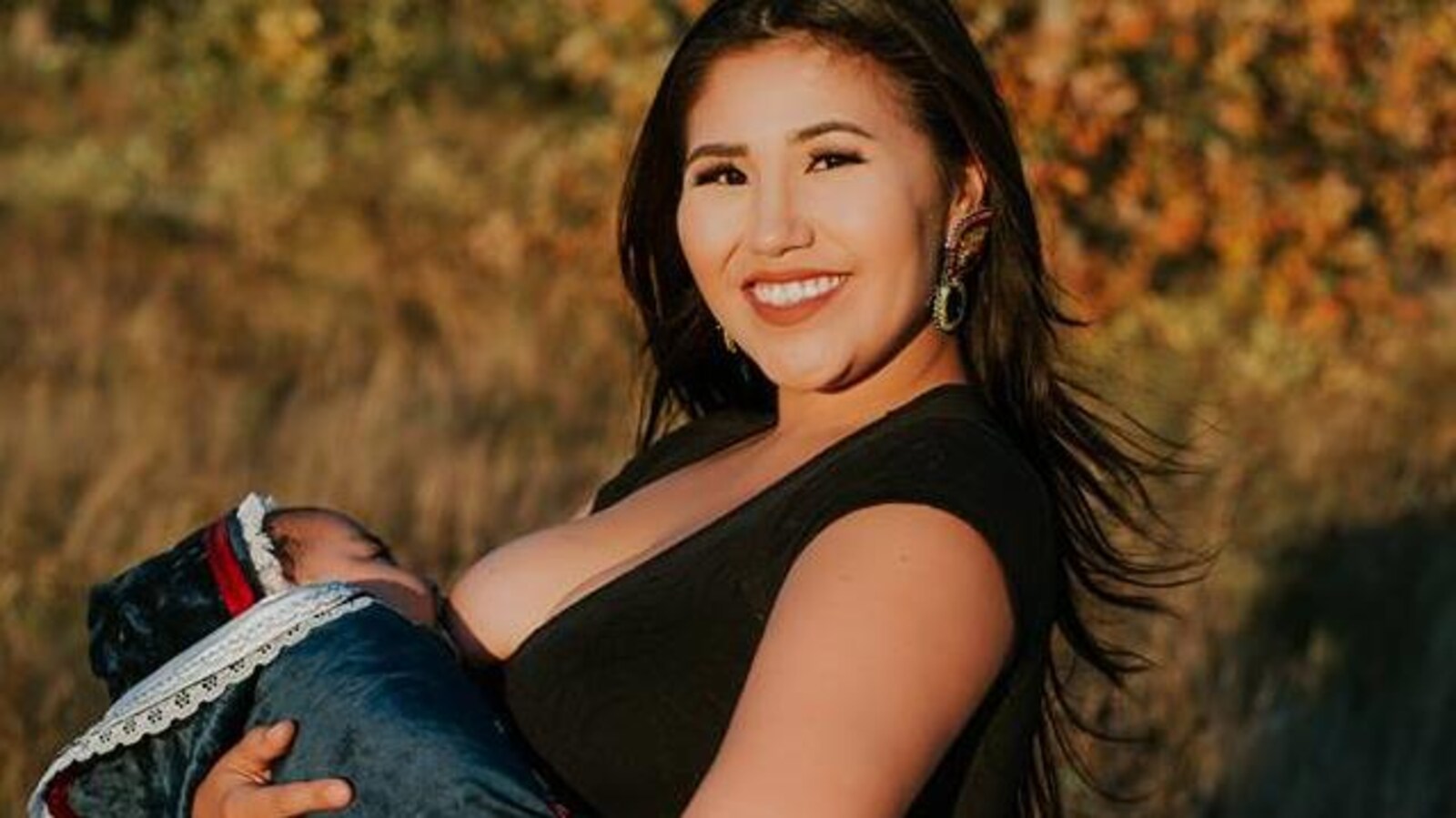 Deidre Sunchild tout sourire en train d'allaiter son bébé.