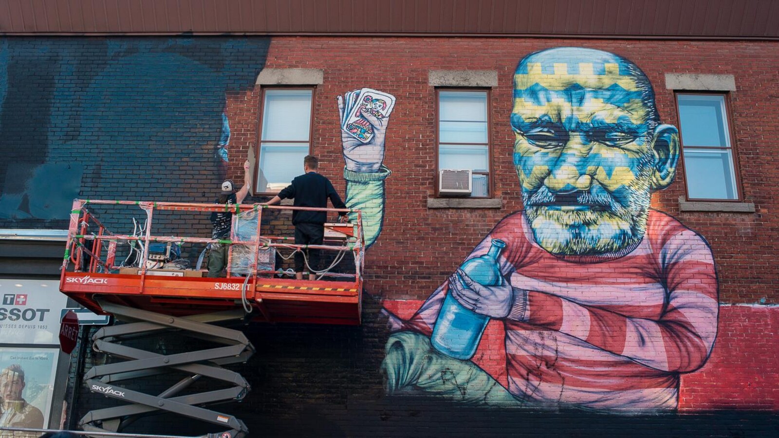 Deux personnes peignent de noir la mural de Other, réalisée en 2013.