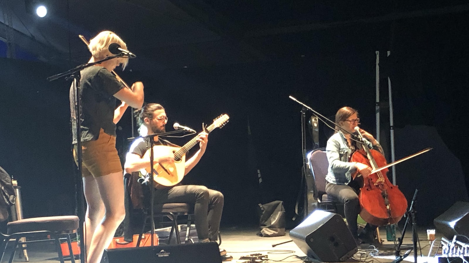 Trois musiciens répètent sur scène.