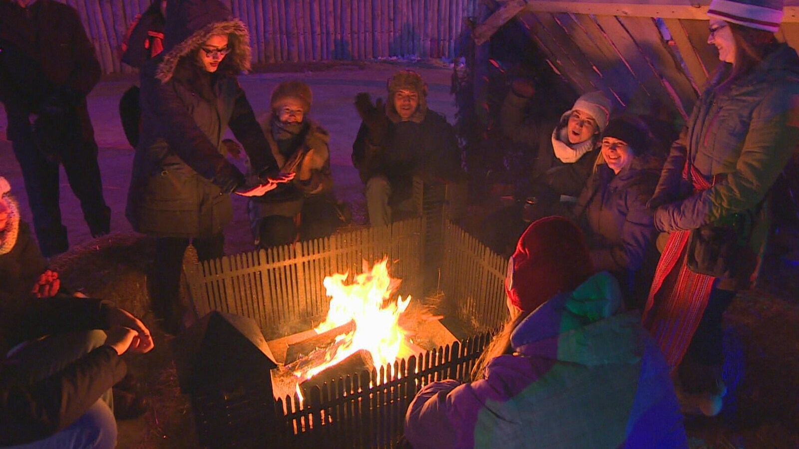 Des gens se réchauffent près d'un feu.