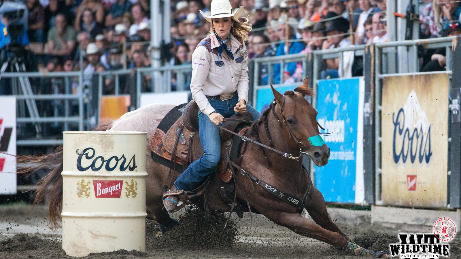 Femme sur un cheval qui contourne un baril
