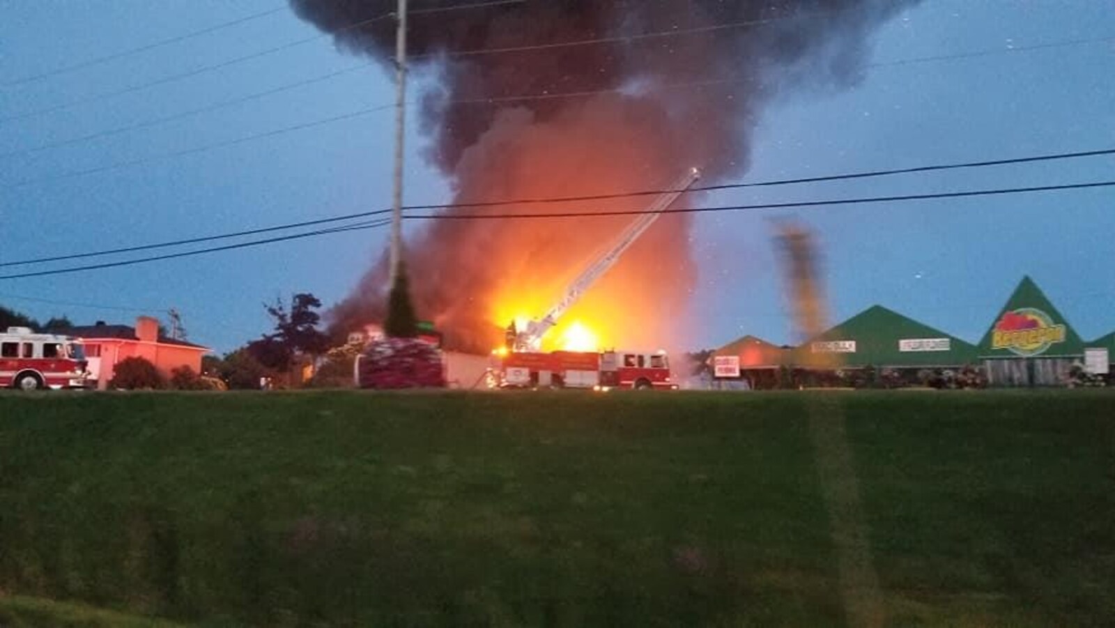 Un camion de pompier devant un bâtiment en feu.