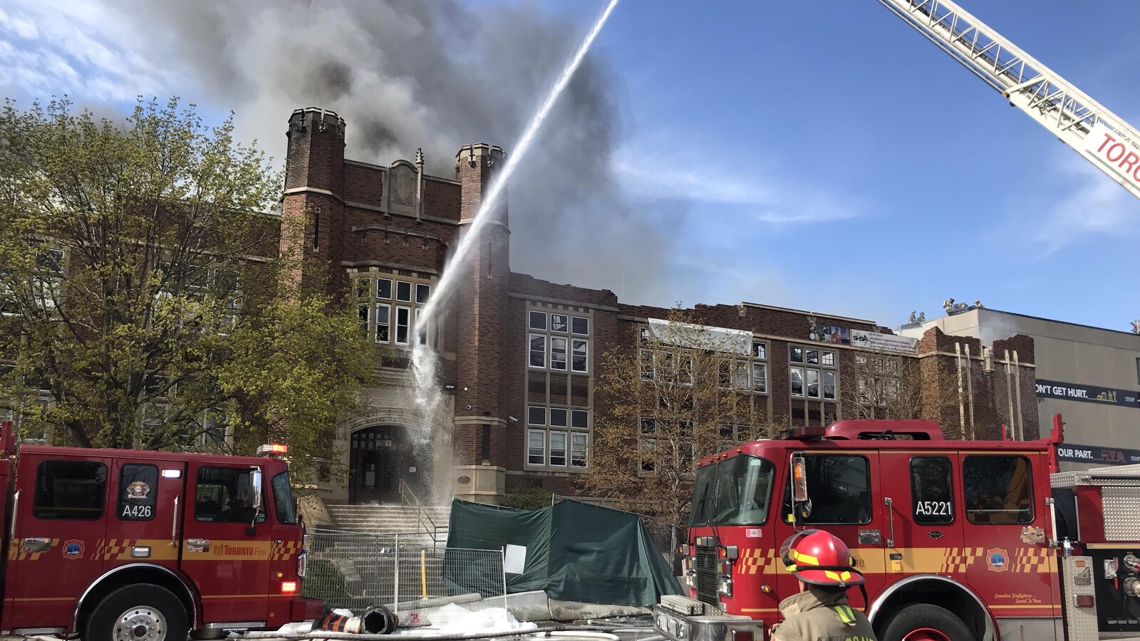 Des pompiers arrosent la façade d'un bâtiment