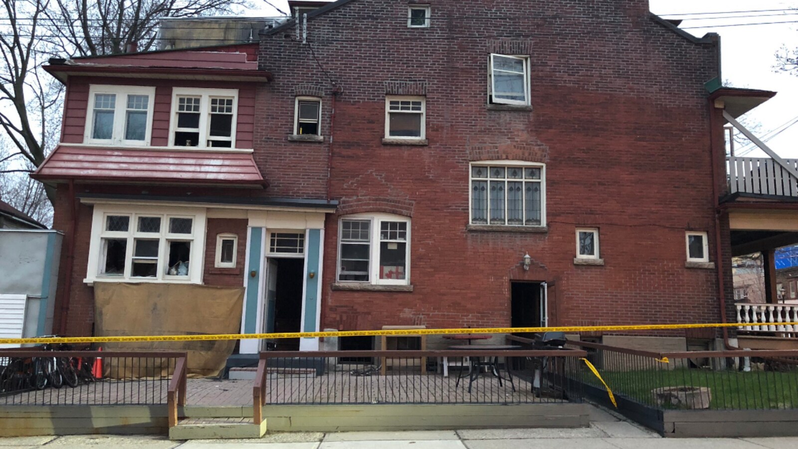 Photo d'une maison en briques entourée d'une banderole de police jaune