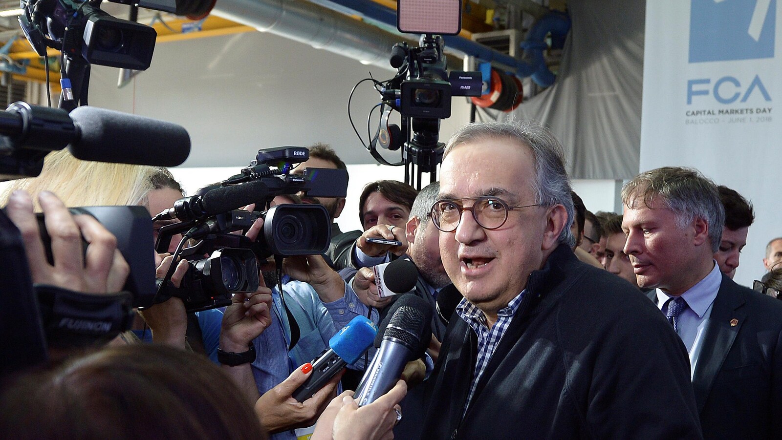 Un homme devant les caméras et les micros des journalistes.