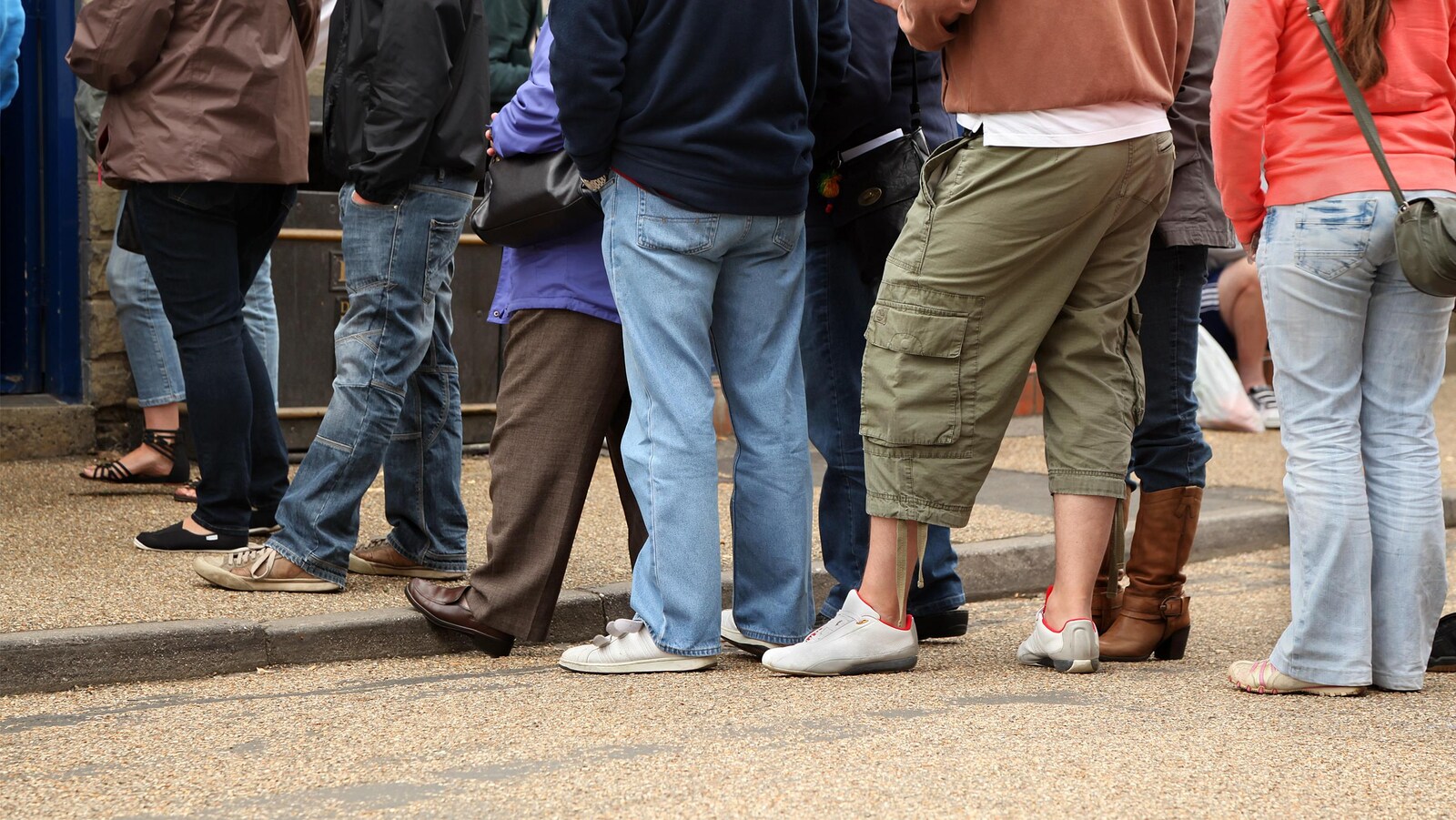 Des gens dont on ne voit pas le visage font la queue pour commander à un restaurant.