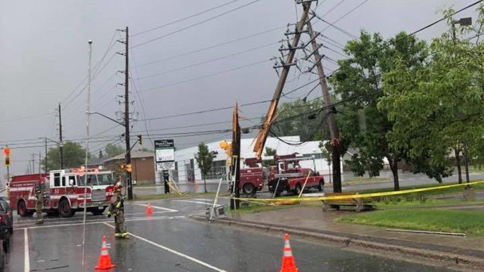 Un poteau électrique brisé. Des pompiers sont autour.