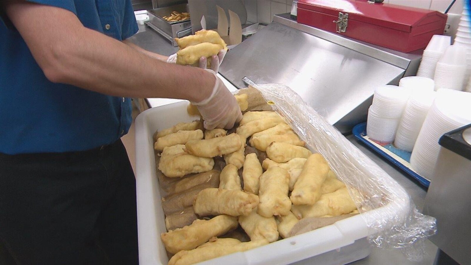 Un employé de restaurant prépare des fish and chips