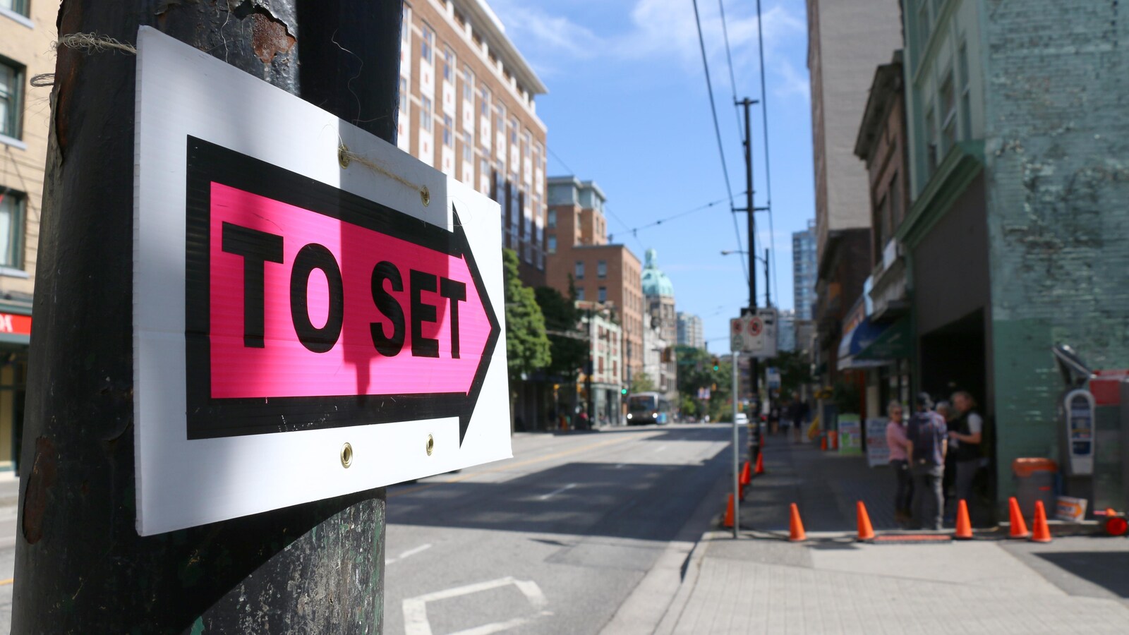 Une flèche pointe vers le site du tournage d'un film délimité par des cônes.