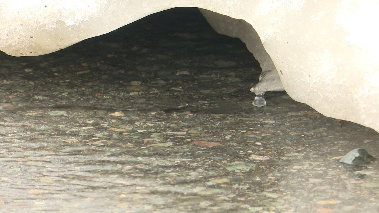Une goutte d'eau coule d'un morceau de glace qui fond.