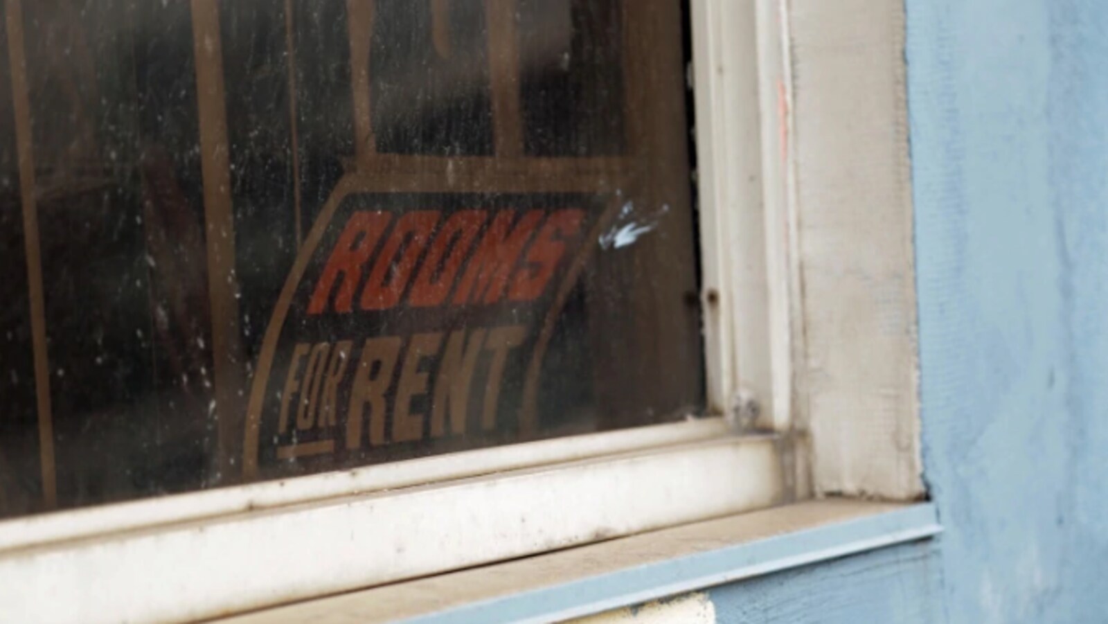Panneau "for rent" affiché à la fanêtre d'une habitation.