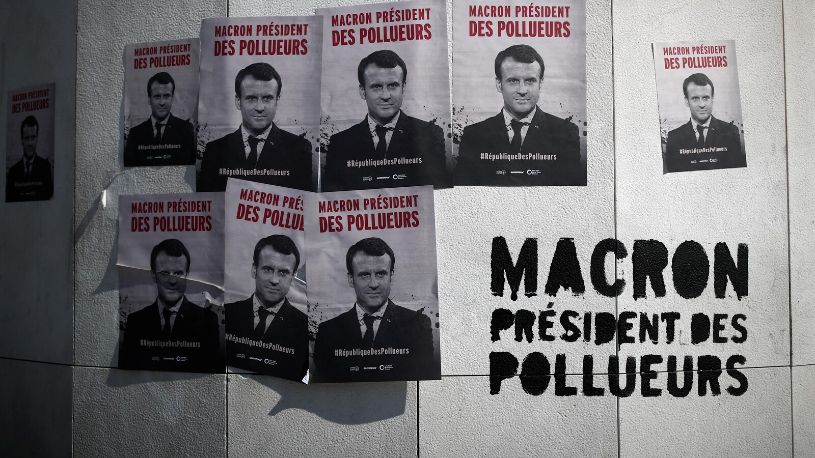Des affiches et un slogan indiquant « Macron, président des pollueurs »
