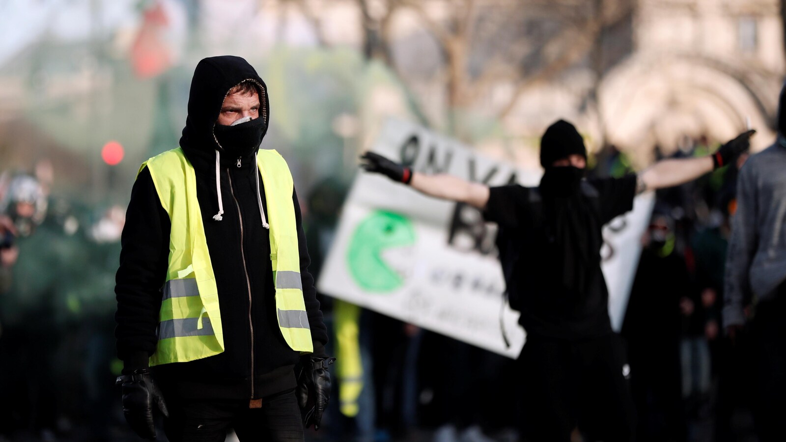 Un homme vêtu d'un gilet jaune et d'une cagoule