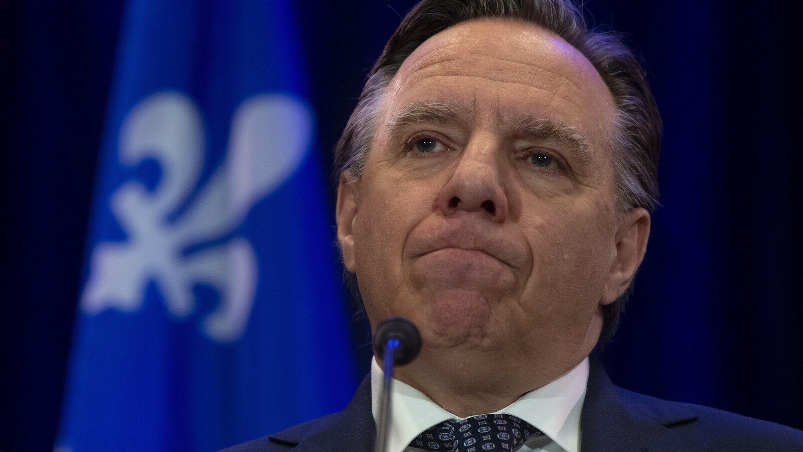 Gros plan de François Legault, qui se mord les lèvres.