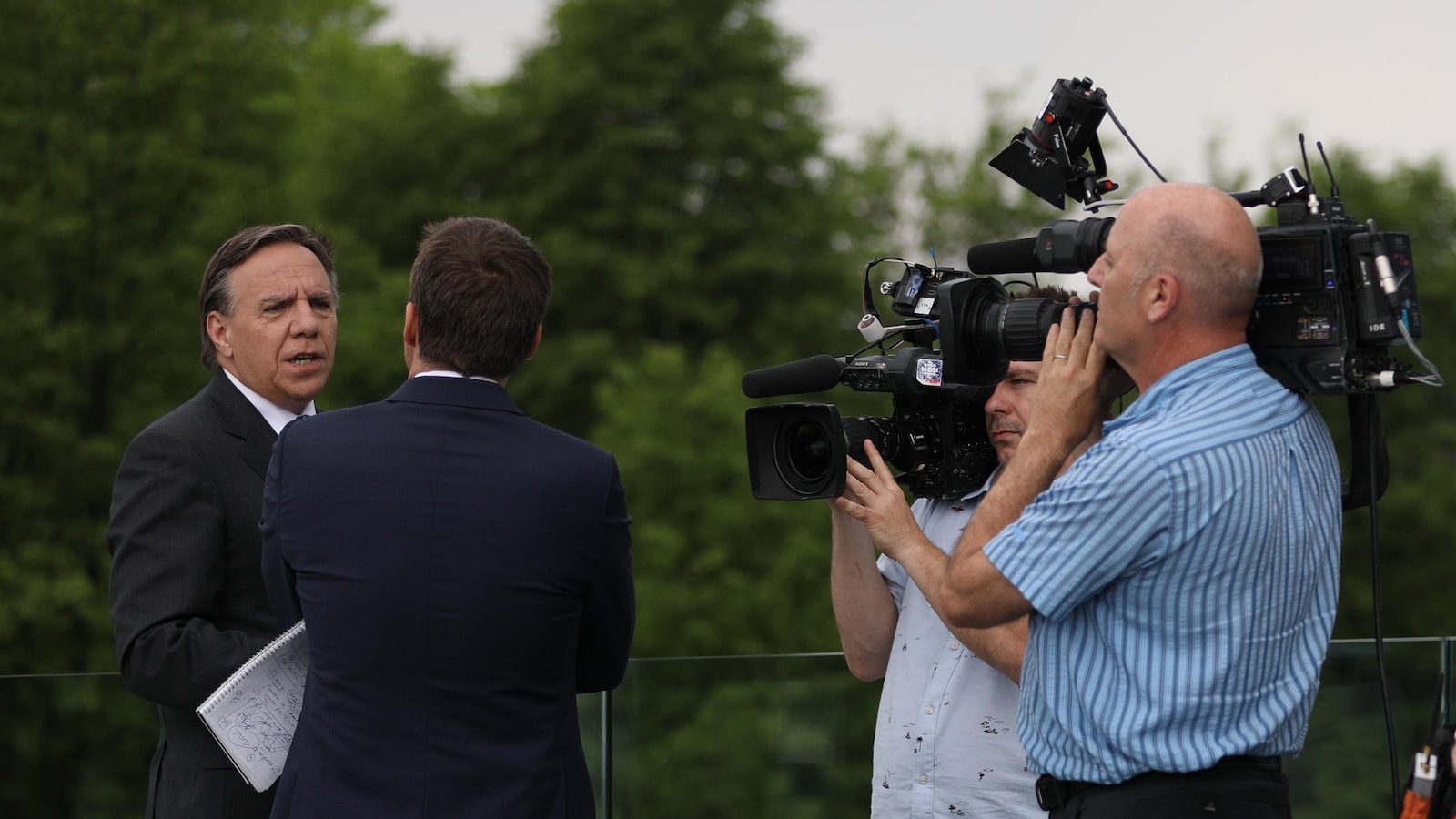 François Legault en entrevue, entourés de 2 caméramans.