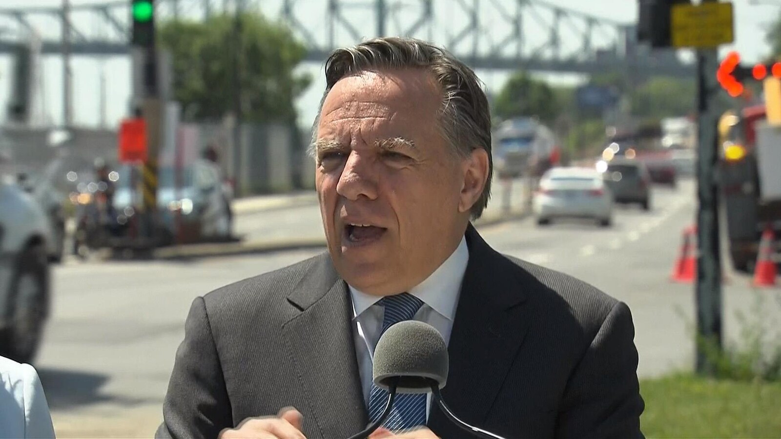 M. Legault s'adresse aux médias en bordure de la rue Notre-Dame, près du pont Jacques-Cartier.