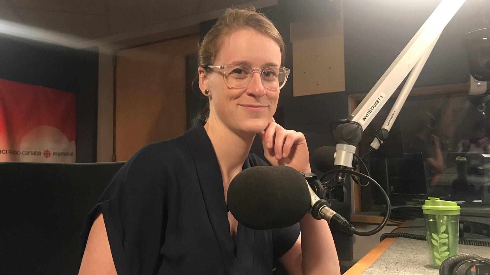 Une femme devant un micro dans un studio radio.