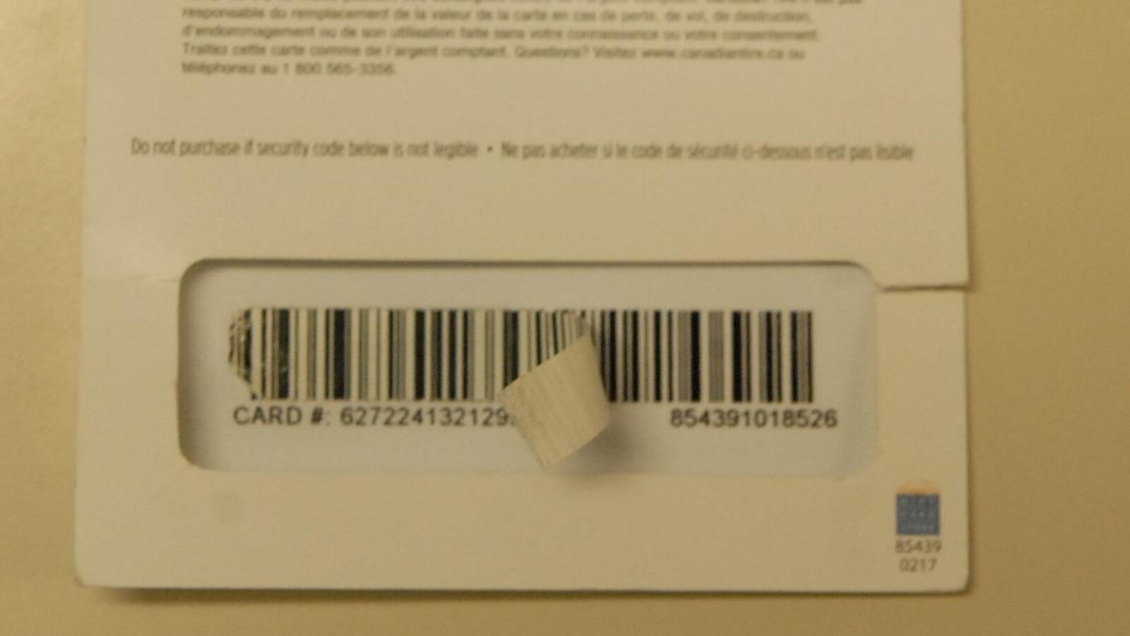 Le code-barre d'une carte-cadeau avec un collant qui décolle