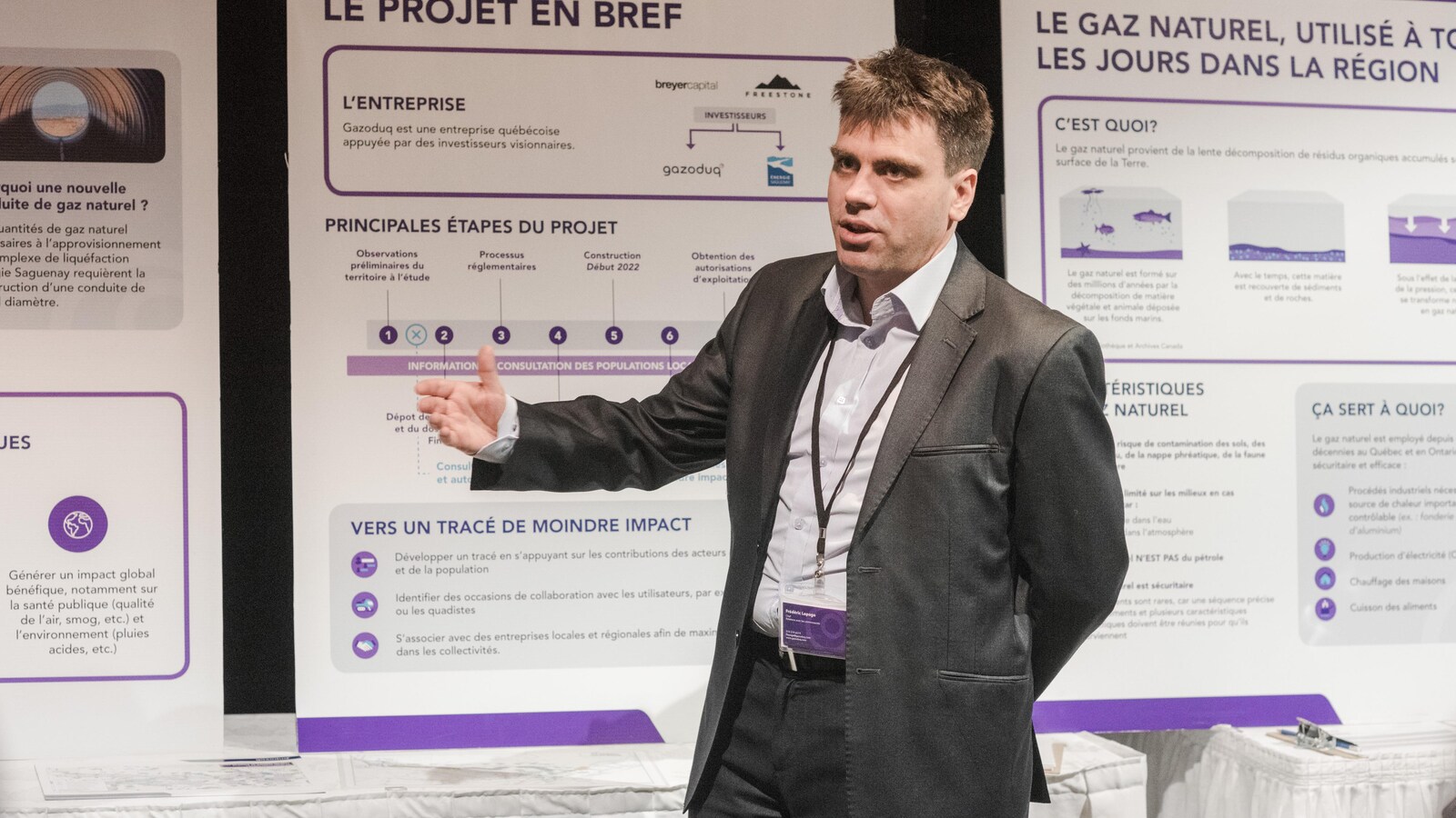 Un homme parle devant une foule lors d'une consultation de l'entreprise Gazoduq.