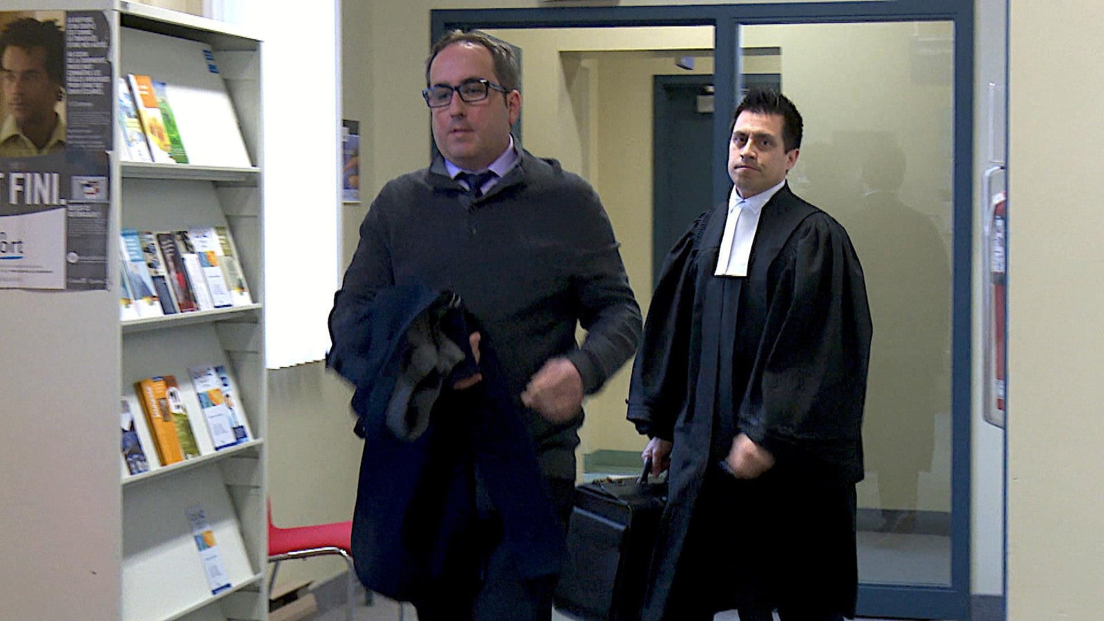 Homme qui marche avec un avocat derrière lui.