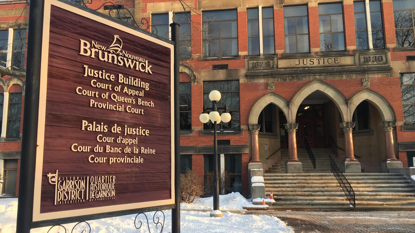 Gros plan sur l'enseigne du palais de justice devant l'édifice.