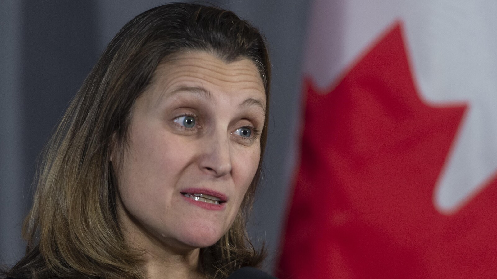 Plan rapproché de la ministre des Affaires étrangères, Chrystia Freeland, devant un drapeau canadien.