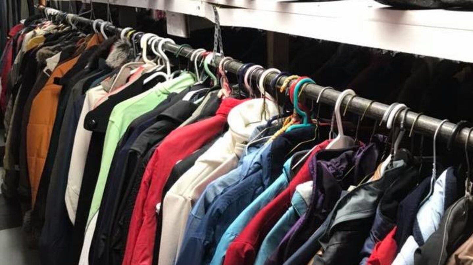 Des vêtements sont disposés dans une friperie.