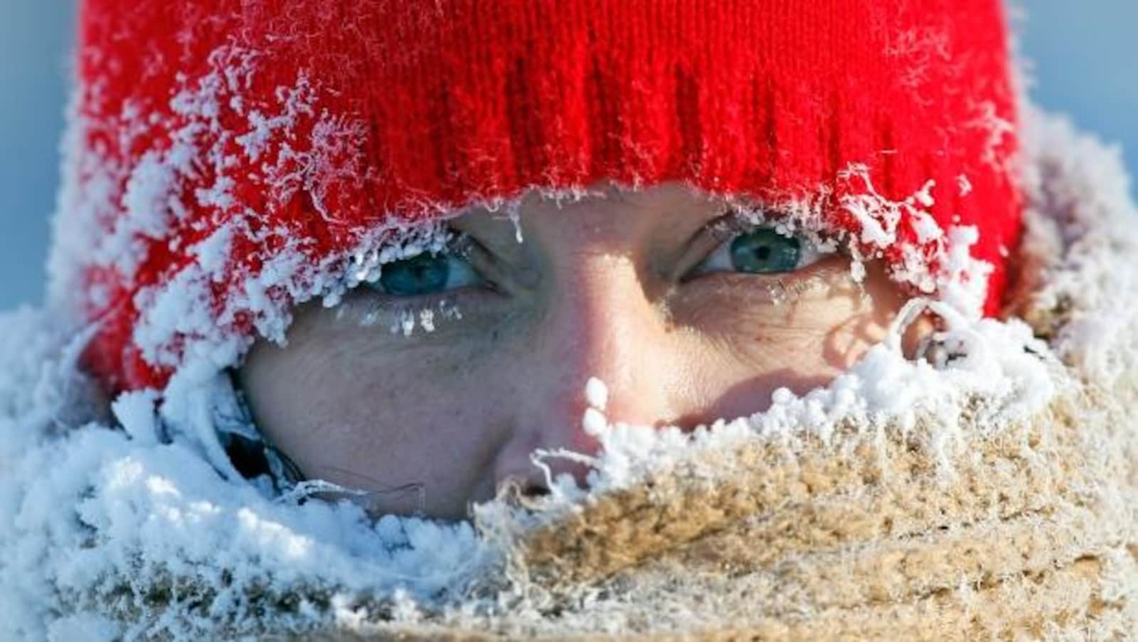 Une femme avec une tuque glacée et de la glace sur ses cils.