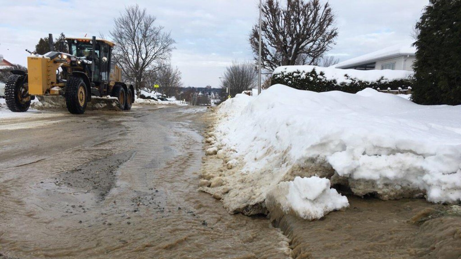 De l'eau s'écoule en grande quantité d'une route municipale de Sherbrooke, dans un secteur résidentiel de l'ouest de la ville.