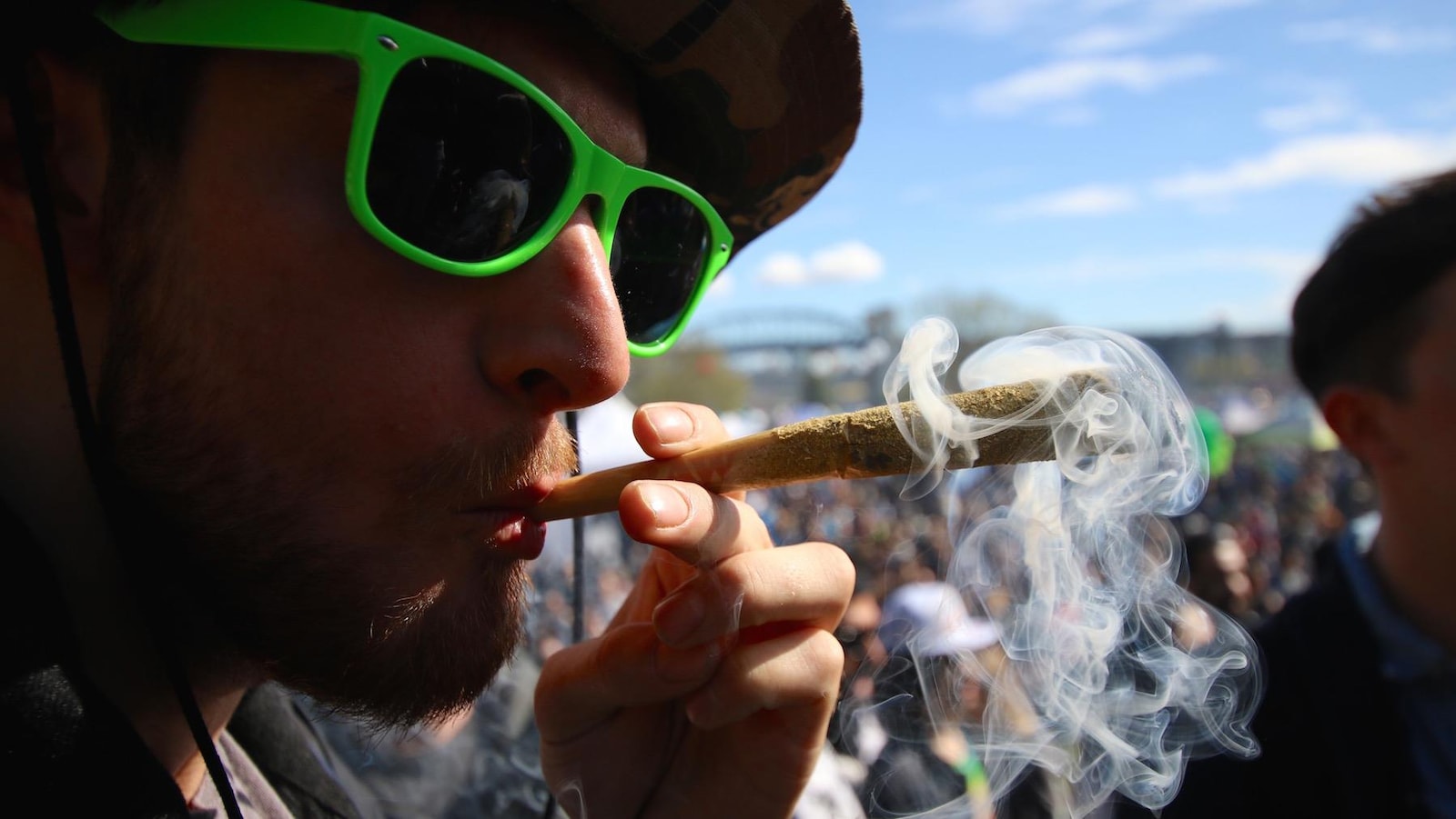 Un participant au 4/20 de Vancouver fume un joint.
