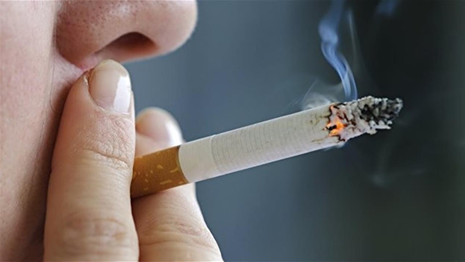 Une femme fume une cigarette.