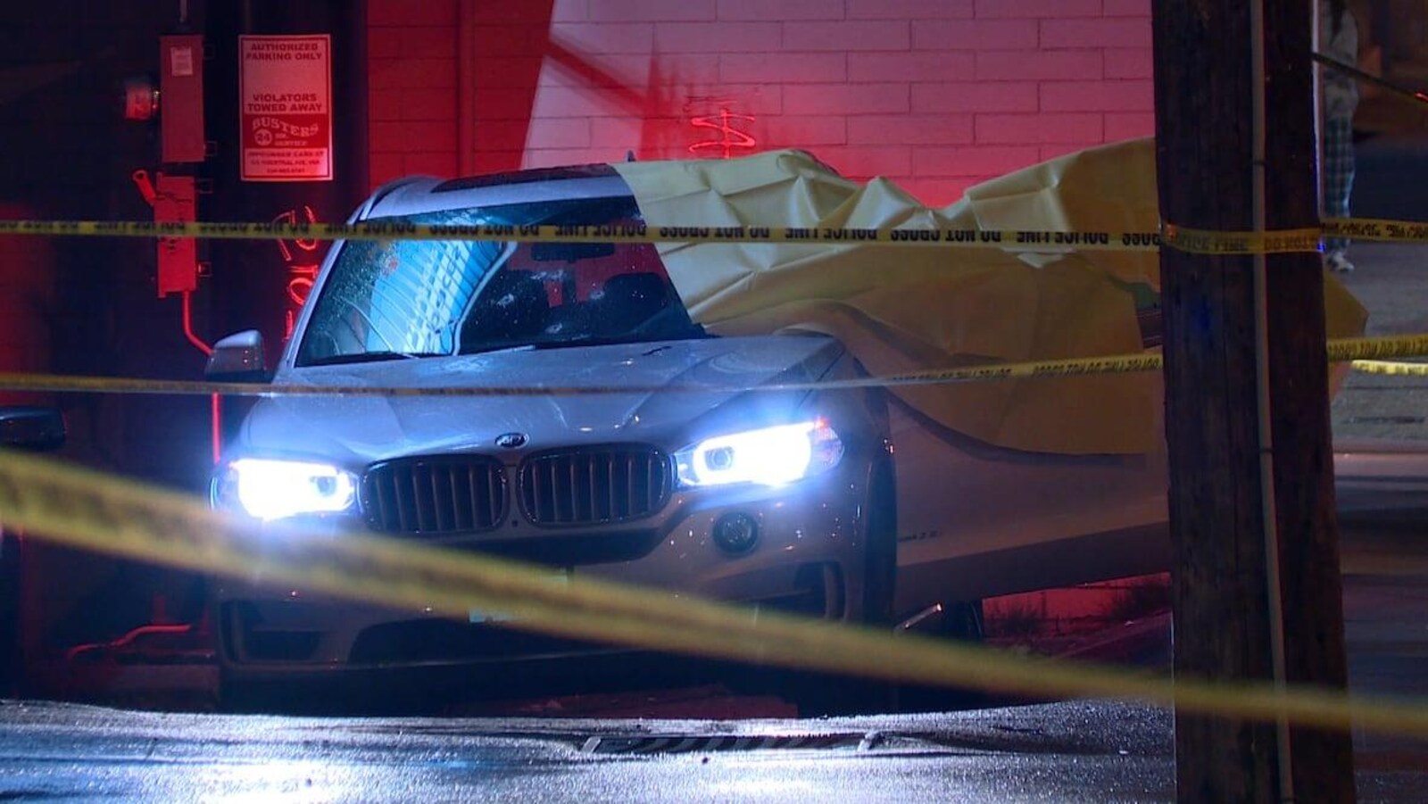 Un VUS blanc entouré de ruban de police.