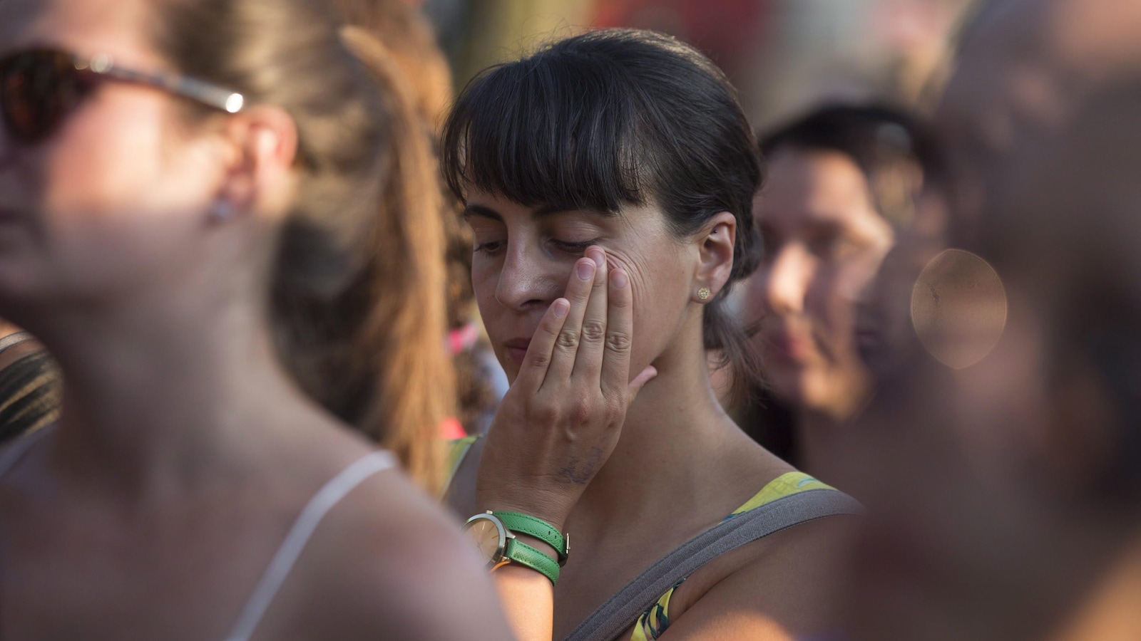 Une femme dans la foule essuie une larme lors du rassemblement.