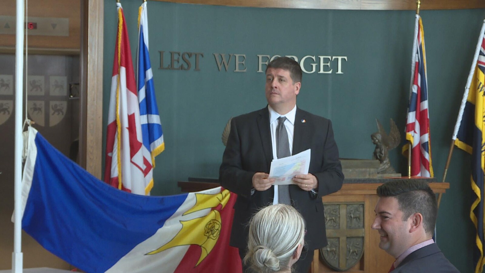 Gaël Corbineau est debout. À l'arrière plan, le drapeau de la francophonie.