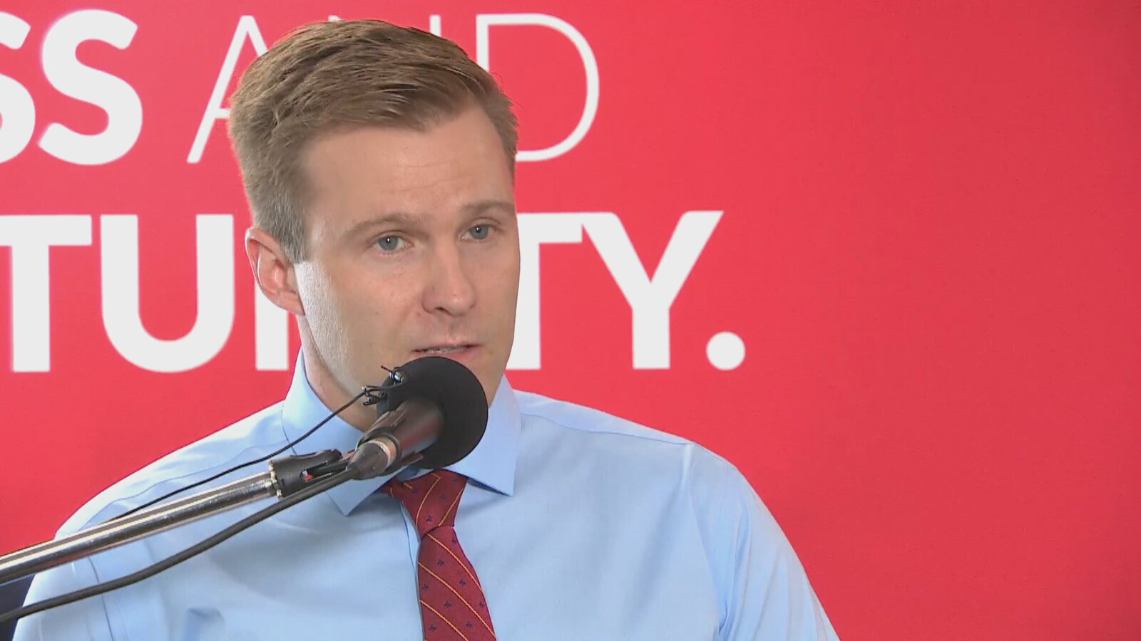Brian Gallant au micro donne une conférence de presse.