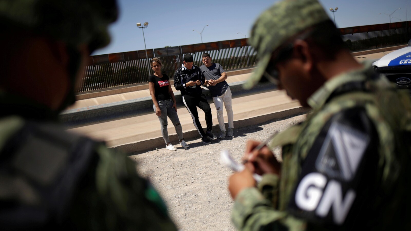 Des membres de la Garde nationale mexicaine détiennent des migrants cubains qui tentaient de franchir illégalement la frontière entre les États-Unis et le Mexique, à Ciudad Juarez.