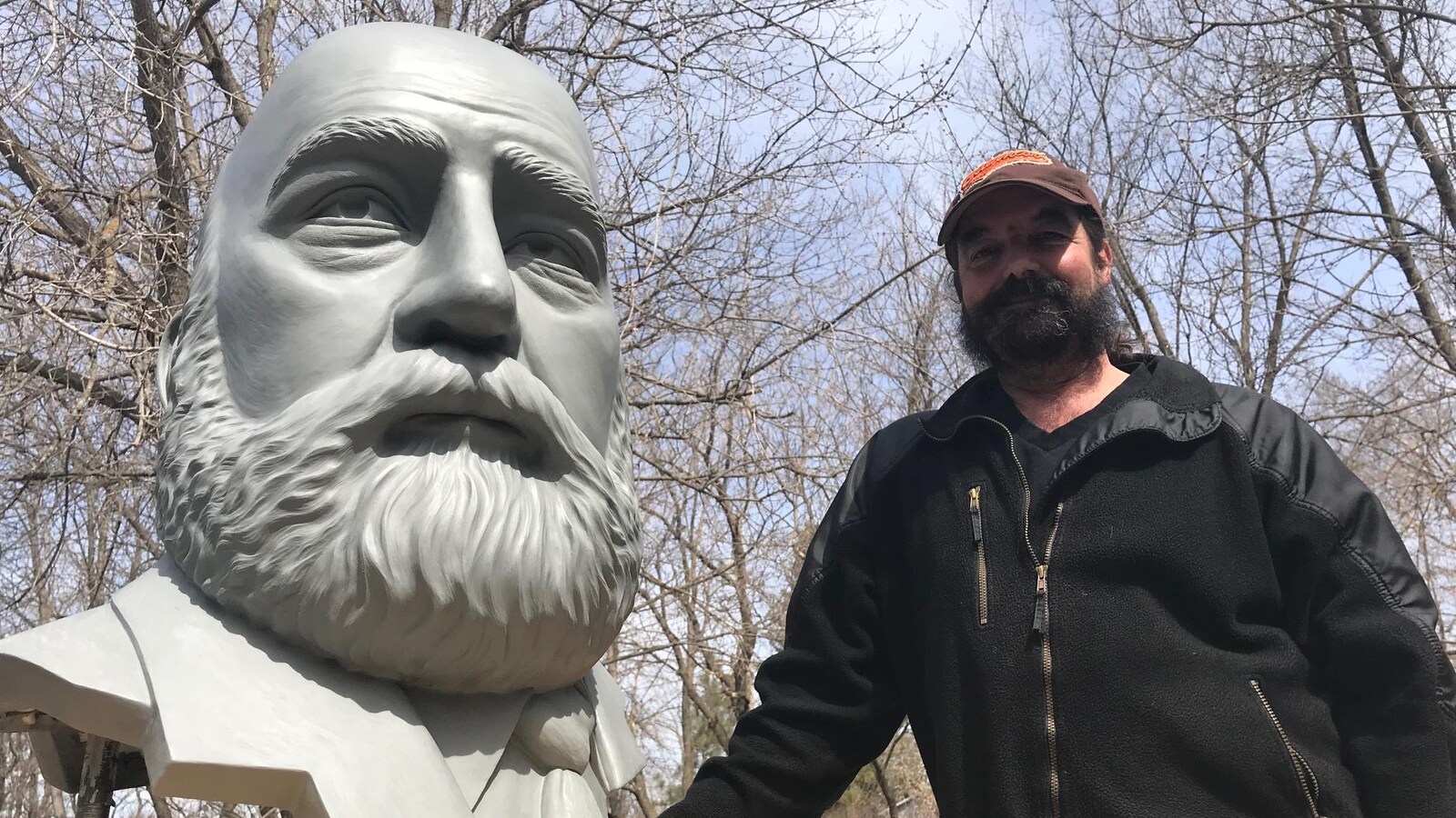 Le buste d'un homme qui doit faire partie d'un monument qui n'est pas encore terminé, etl'artiste qui l'a sculpté.