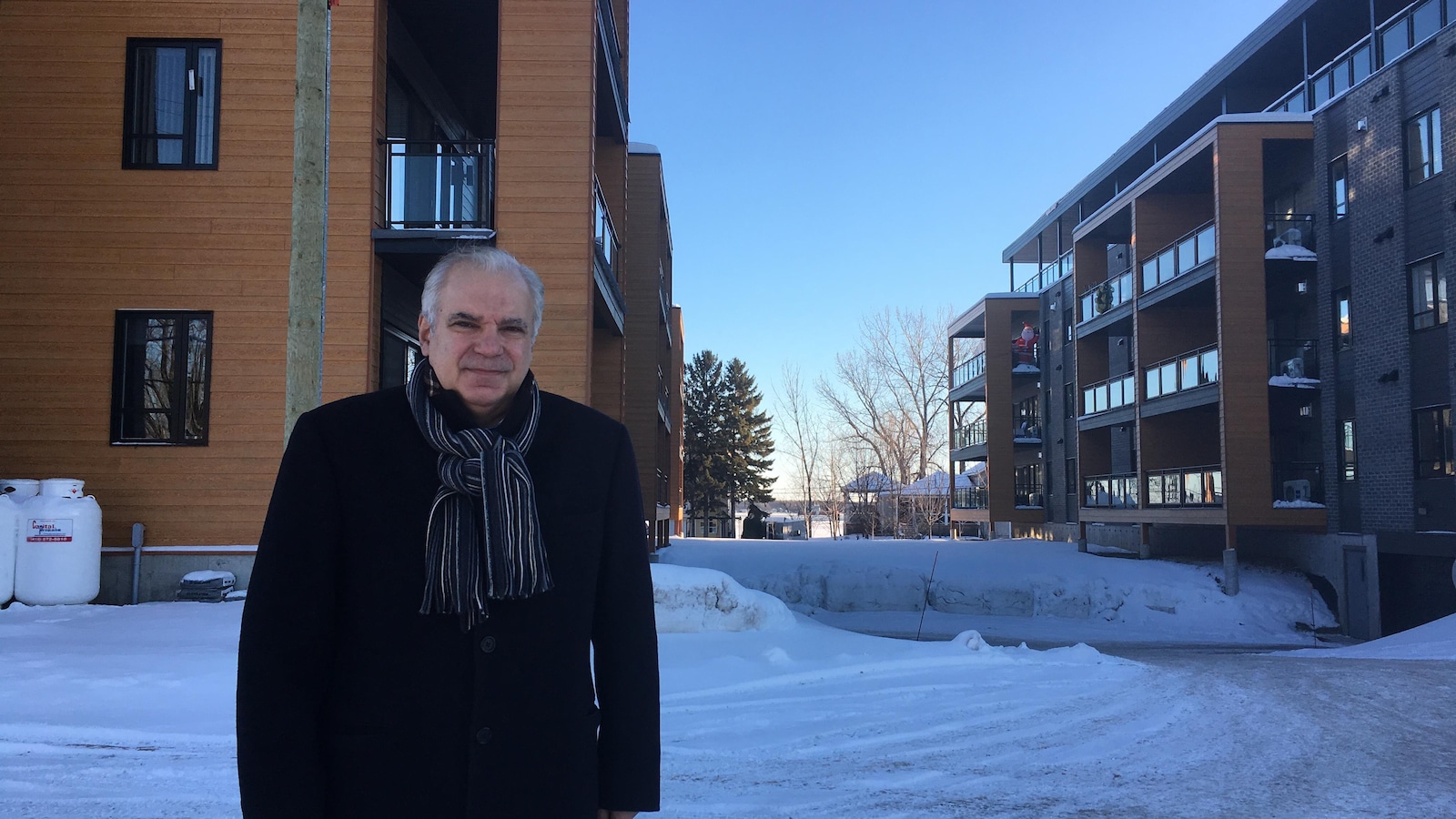 Georges Mouradian se tient devant l'un des multiplex de son projet domiciliaire.