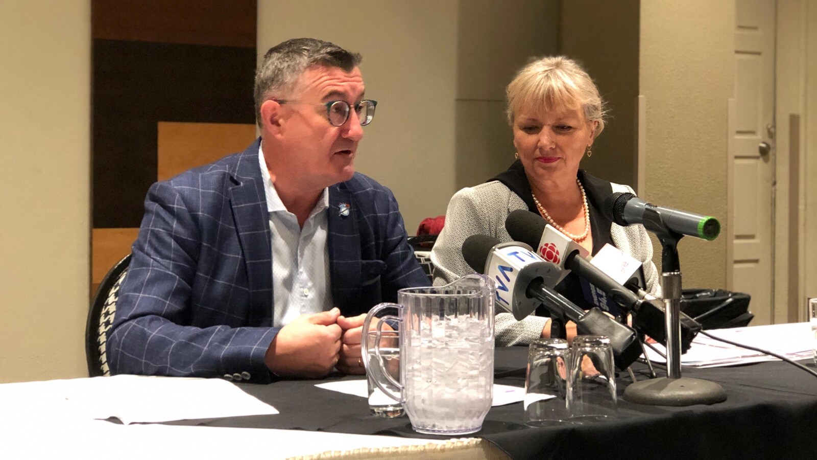 Étienne Jacques et Joan Simard assis à une table derrière des micros.