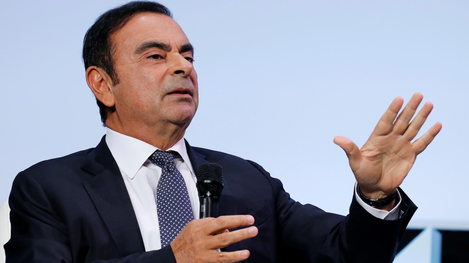 Carlos Ghosn tient un micro.