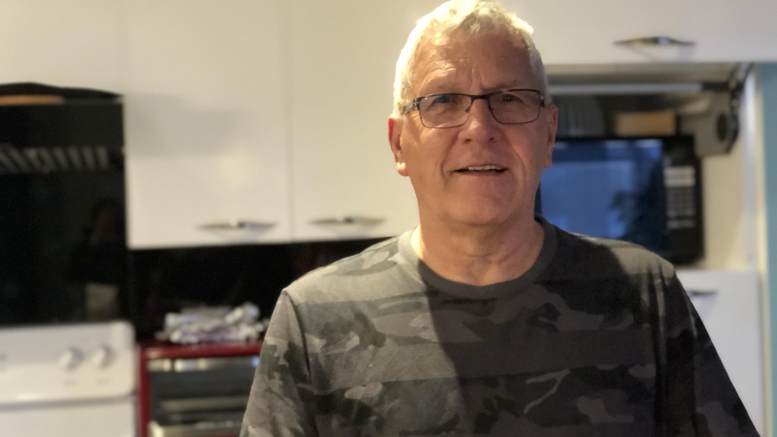 Gilbert Richard debout dans la cuisine de sa maison.