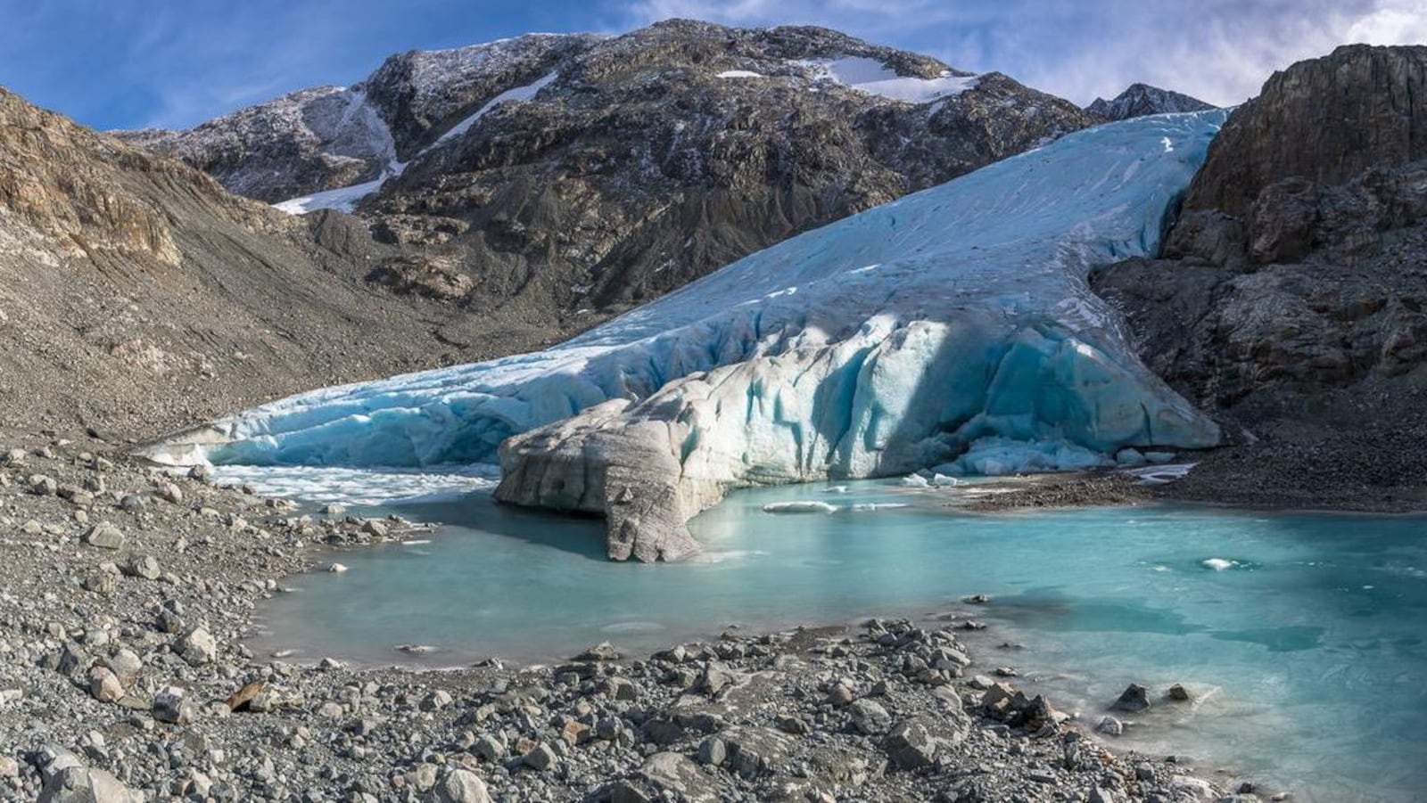 De la glace qui s'avance et fond dans un lac sur des rochers