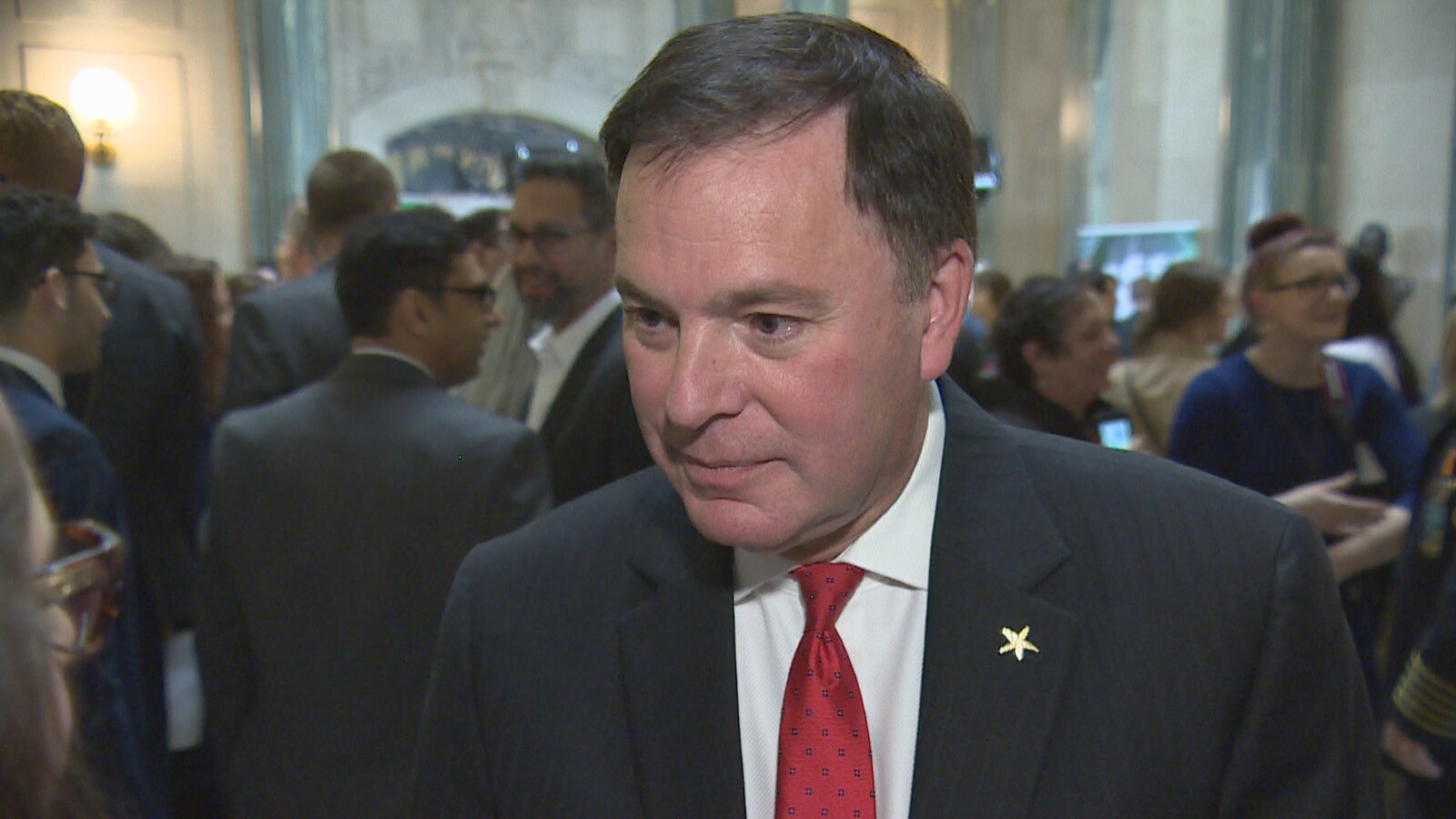 Gordon Wyant regarde les journalistes en écoutant leurs questions concernant le budget. Il porte une cravate rouge.