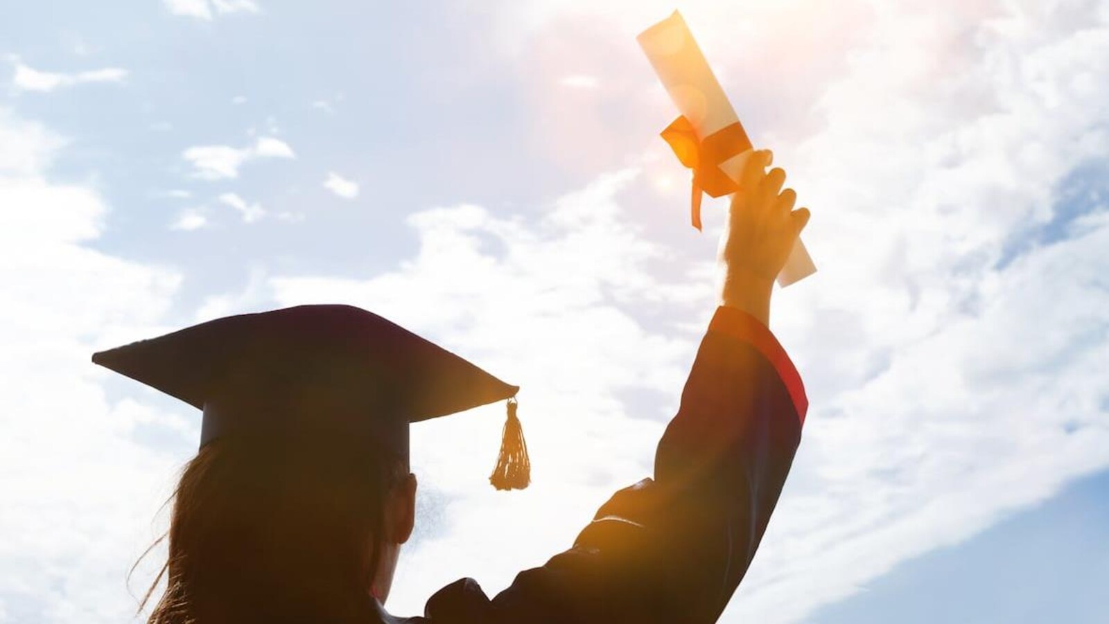 Un élève soulève son diplome lors de sa graduation.