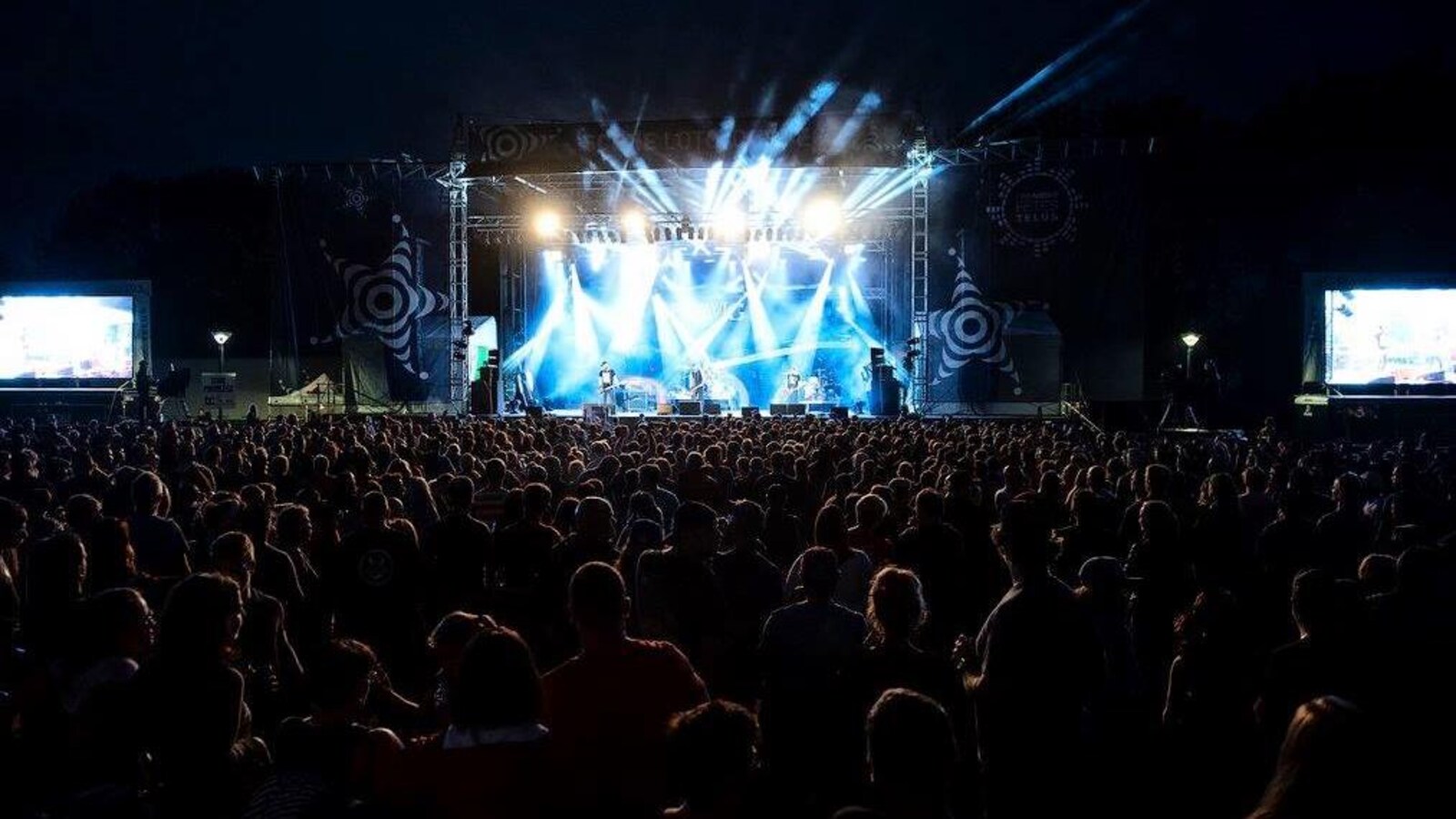 Un spectacle sur une scène extérieure avec une foule