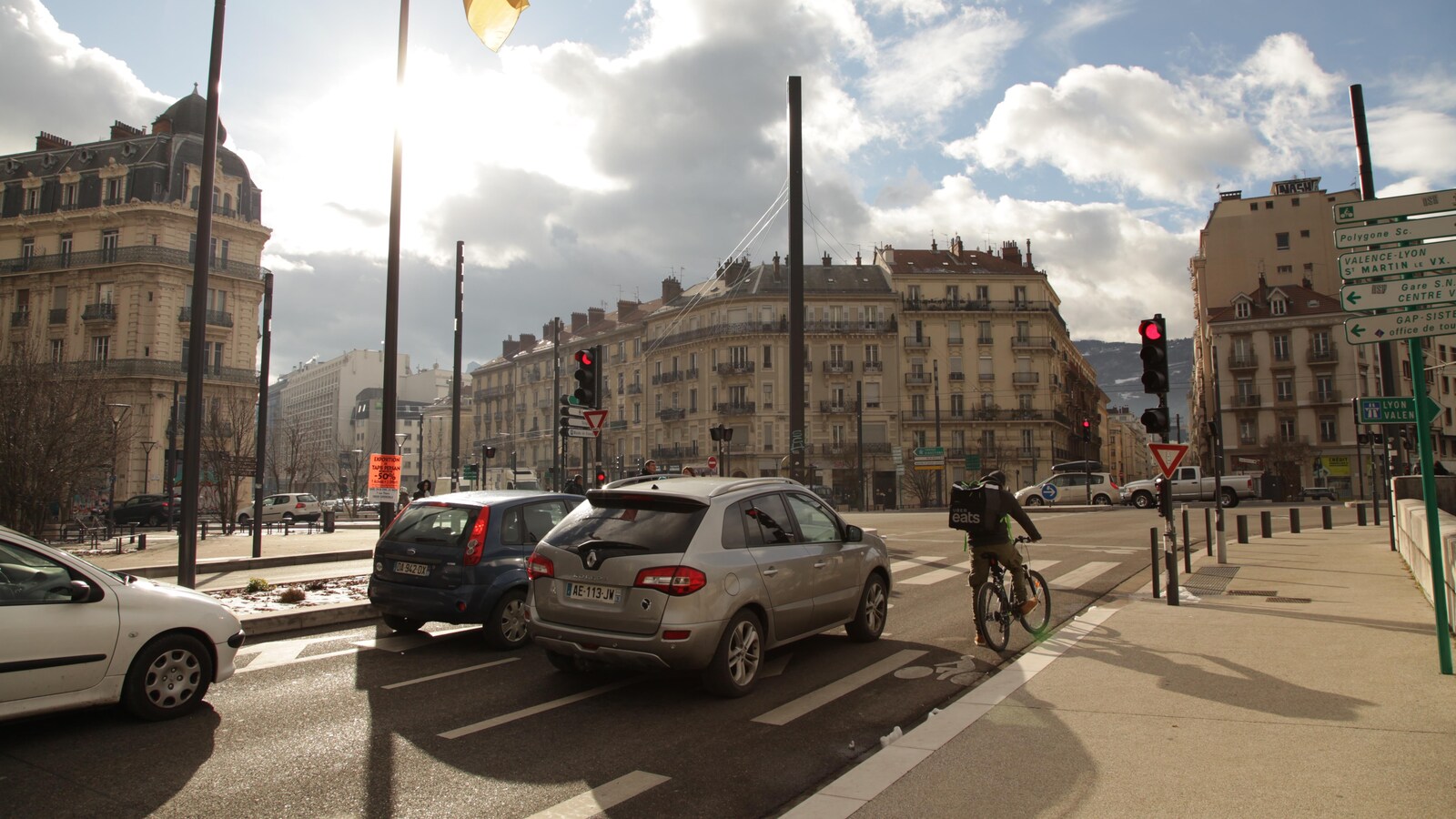 Un cycliste sur une piste cyclable, en bordure de la route