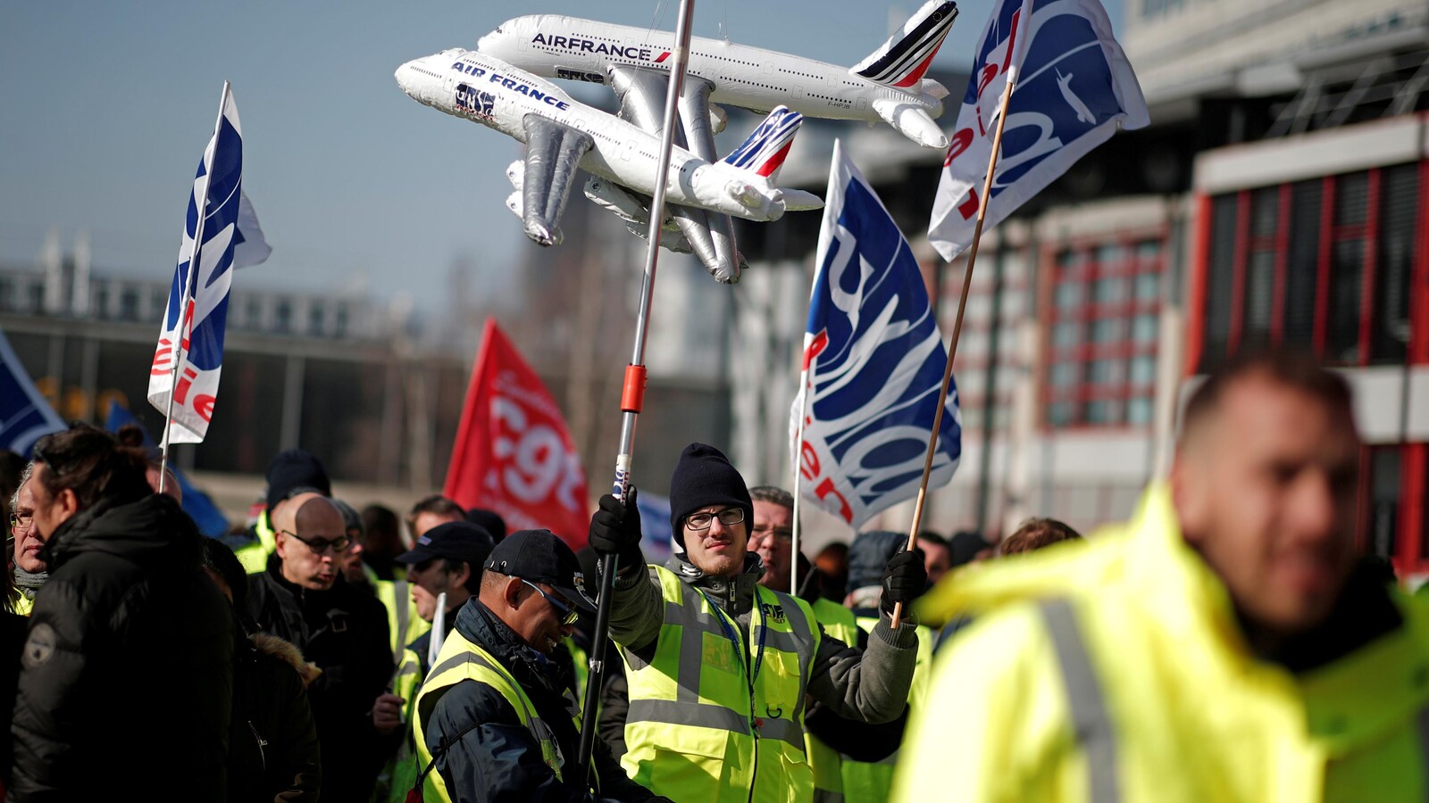 Des grévistes brandissent des drapeaux.