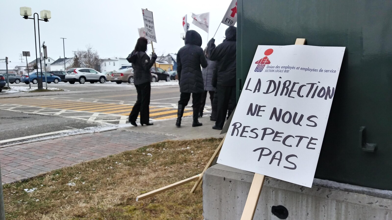 Travailleurs qui manifestent dehors.Pancarte. « La direction ne nous repecte pas. »