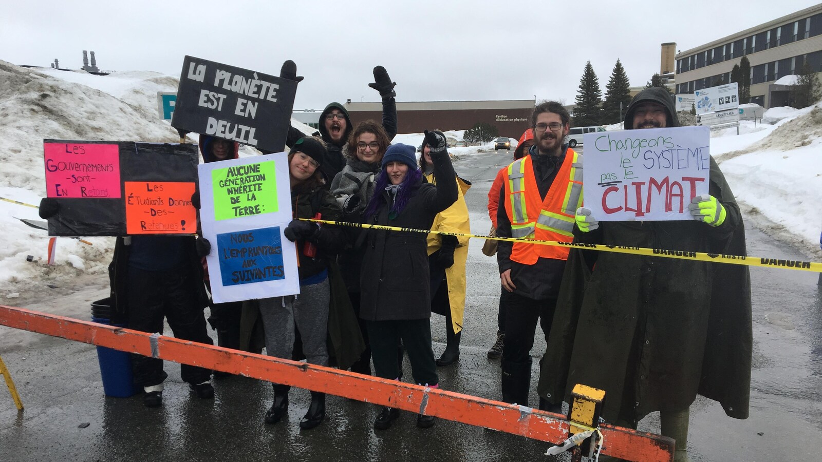 Des étudiants tiennent des affiches avec des slogans en faveur de la protection de l'environnement.